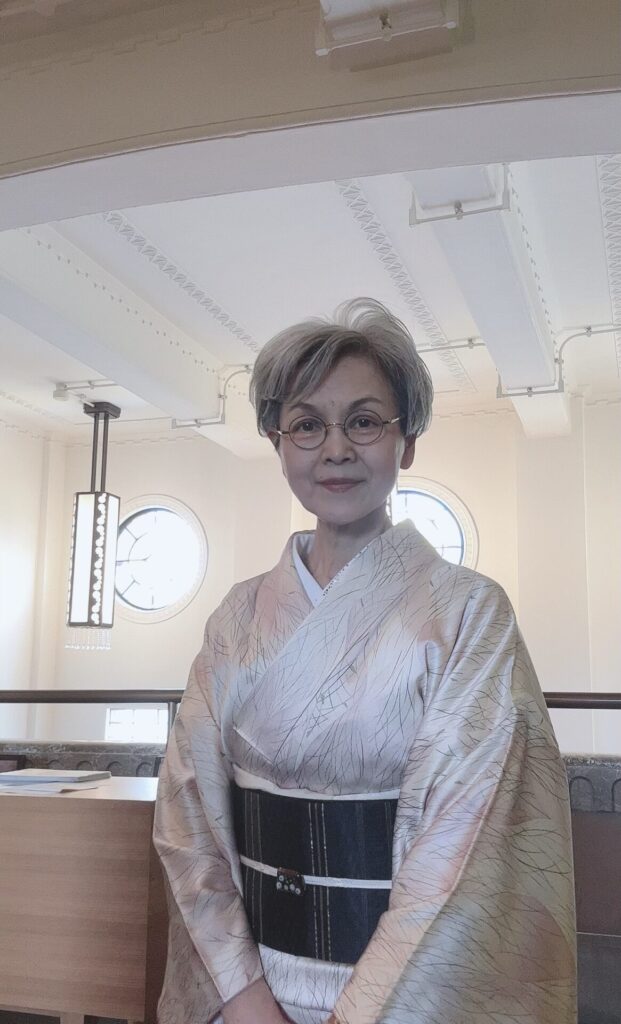 薄ピンクの少し派手な着物に年相応の黒い帯を締めた写真