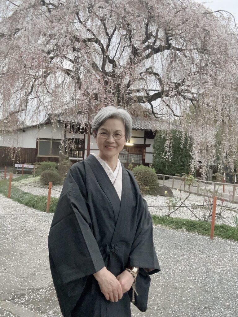 満開の枝垂れ桜を背に